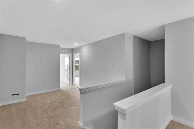 a view of a kitchen with white cabinets and wooden floor
