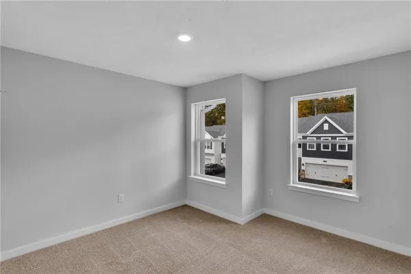 a view of an empty room with windows and cabinet