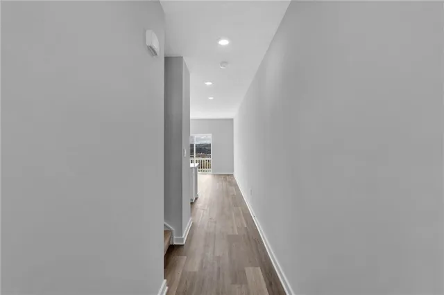 a view of a hallway with wooden floor