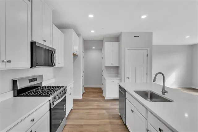 a kitchen with stainless steel appliances a sink stove and cabinets