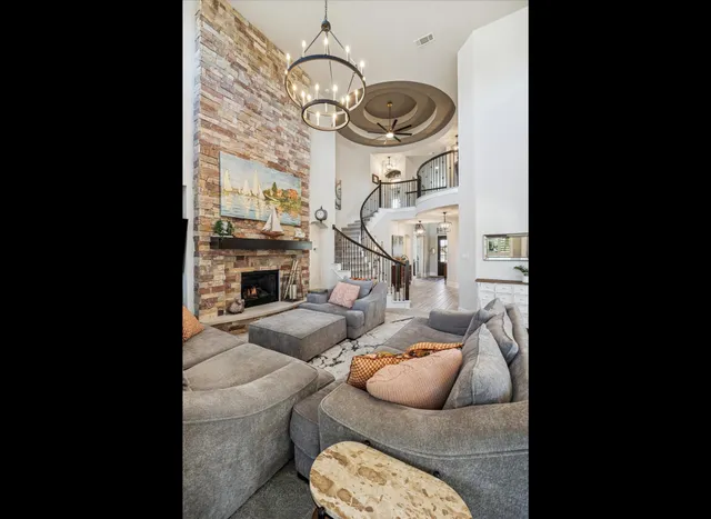 a living room with furniture a fireplace and a chandelier