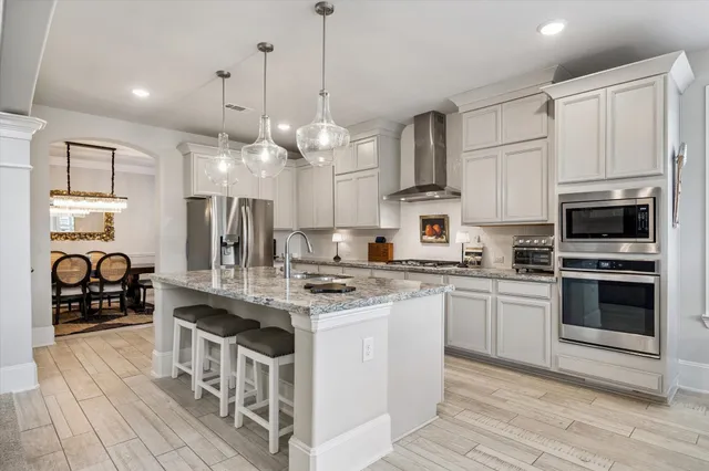 a kitchen with kitchen island granite countertop a sink cabinets and stainless steel appliances