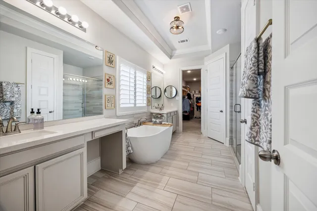 a large spacious bathroom with a double vanity sink a large mirror and a bathtub