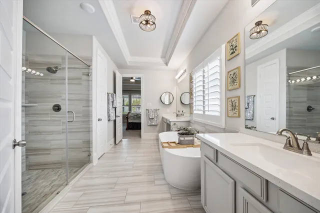 a large spacious bathroom with a granite countertop sink a mirror a bathtub and shower
