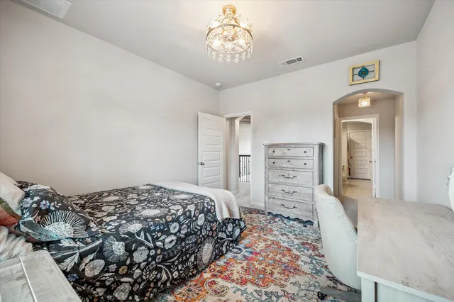 a bedroom with a bed and a flat tv screen on dresser