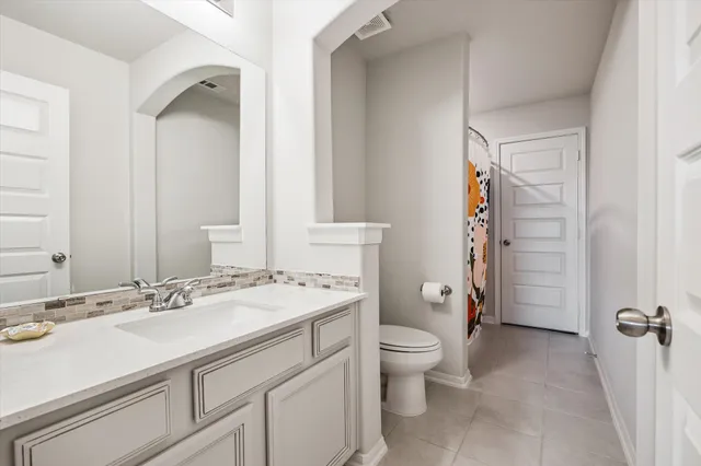 a bathroom with a sink toilet double vanity and shower