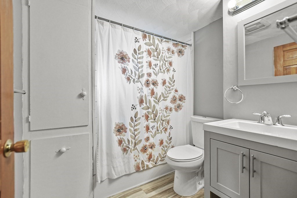 242 Eastern Avenue Lynn, MA 01902 - Photo 18 of 23 a bathroom with a toilet a sink and a mirror