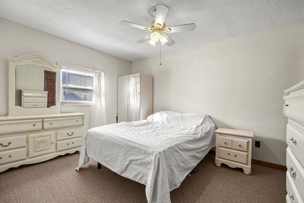 242 Eastern Avenue Lynn, MA 01902 - Photo 19 of 23 a bedroom with a bed and a chandelier