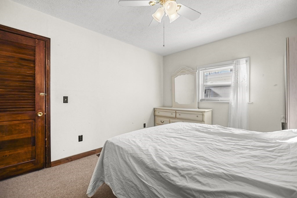 242 Eastern Avenue Lynn, MA 01902 - Photo 20 of 23 a bedroom with a large bed and a chandelier