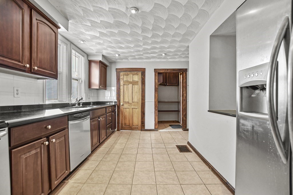 242 Eastern Avenue Lynn, MA 01902 - Photo 2 of 23 a large kitchen with stainless steel appliances granite countertop a refrigerator and a sink