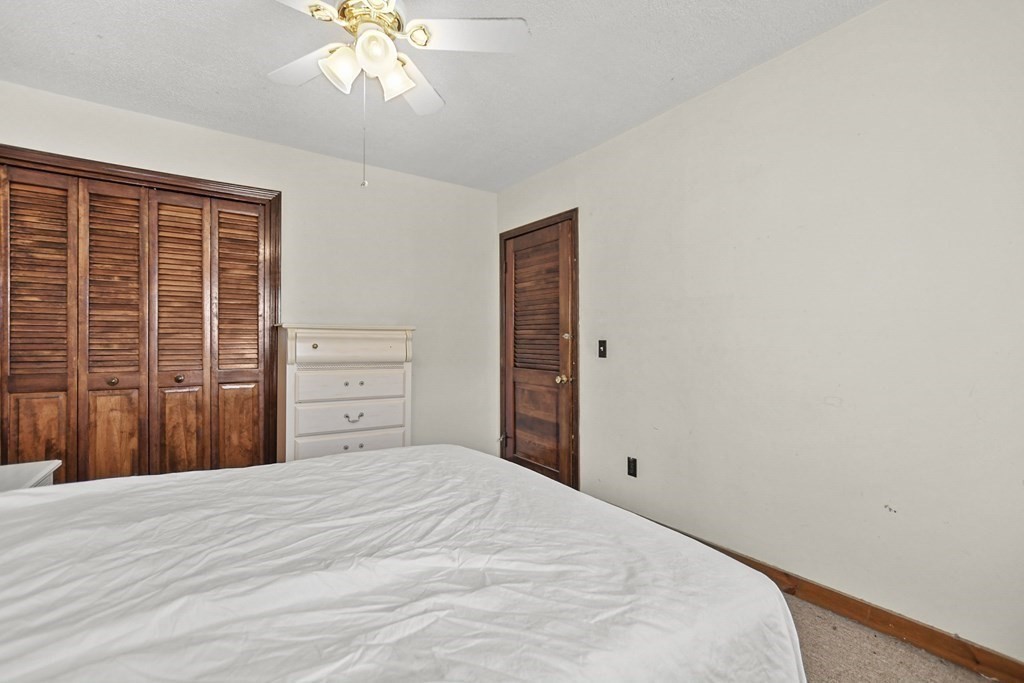 242 Eastern Avenue Lynn, MA 01902 - Photo 21 of 23 a bedroom with a bed and a chandelier