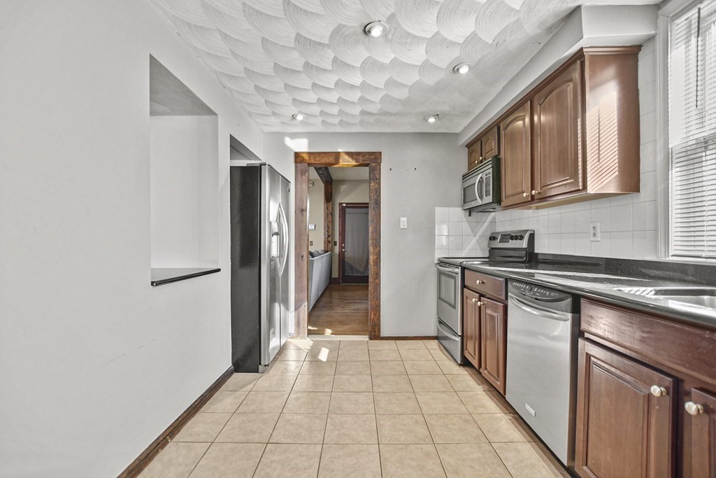 242 Eastern Avenue Lynn, MA 01902 - Photo 4 of 23 a kitchen with stainless steel appliances granite countertop a refrigerator and a sink