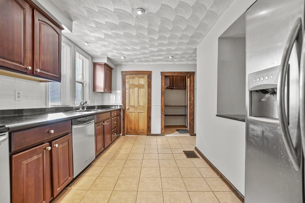 242 Eastern Avenue Lynn, MA 01902 - Photo 6 of 23 a large kitchen with stainless steel appliances granite countertop a refrigerator and a sink