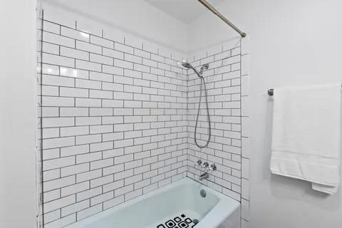a bathroom with a bathtub and next to a shower