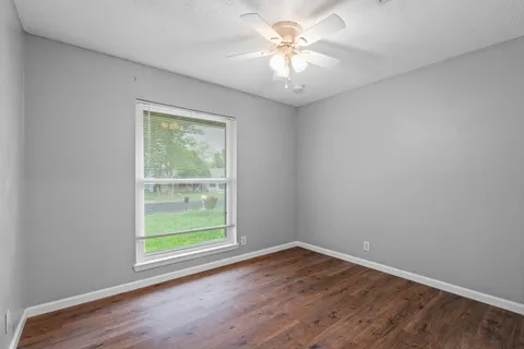 an empty room with wooden floor and a window