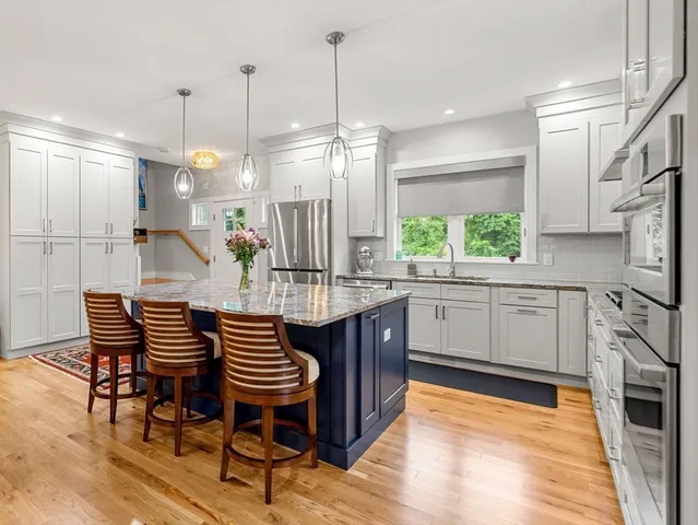 a kitchen with stainless steel appliances kitchen island granite countertop a sink and cabinets