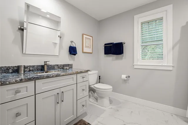 a bathroom with a toilet sink double vanity and mirror