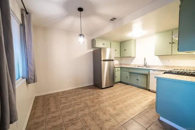 a kitchen with a sink a refrigerator and window