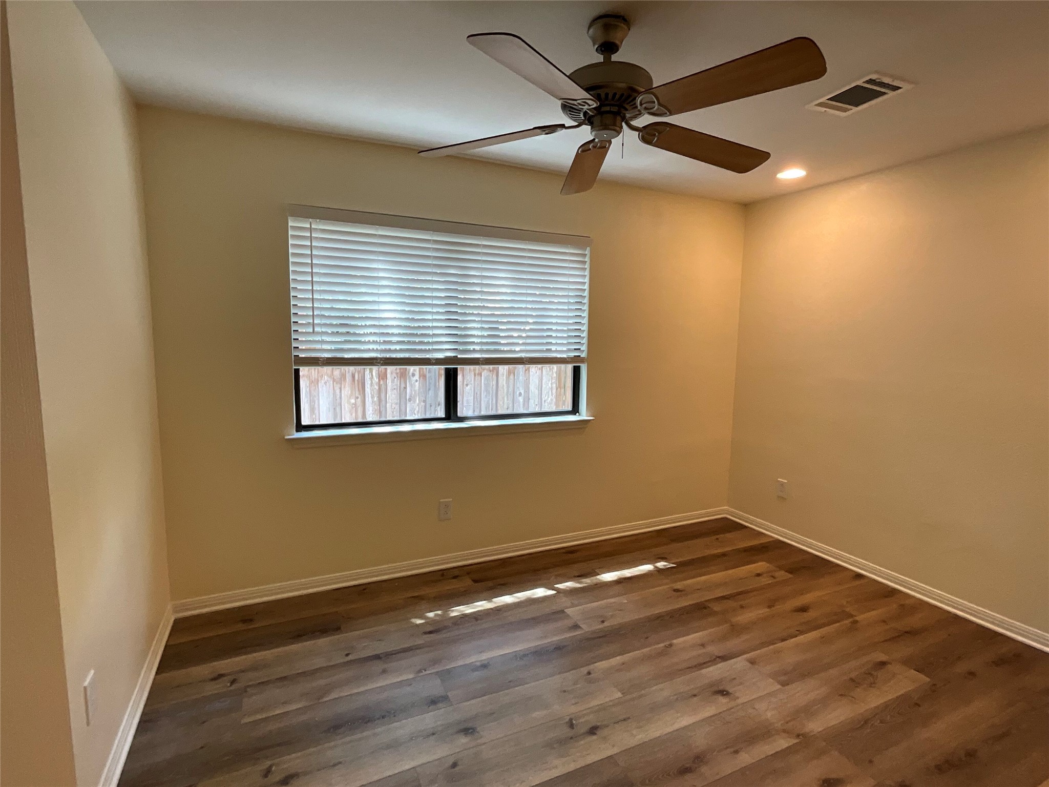 15702 Racine Cove Austin, TX 78717 - Photo 26 of 27 A comfortable bedroom features warm-toned walls, rich wood-look flooring, and a ceiling fan for year-round comfort.