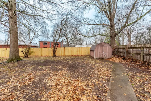 a backyard of a house with barbeque oven table and chairs