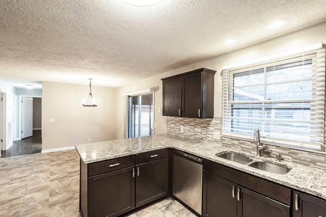a kitchen with granite countertop a sink and cabinets