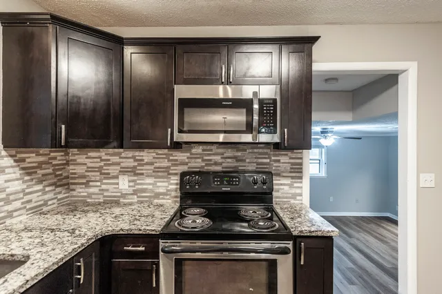 a kitchen with granite countertop stainless steel appliances and cabinets