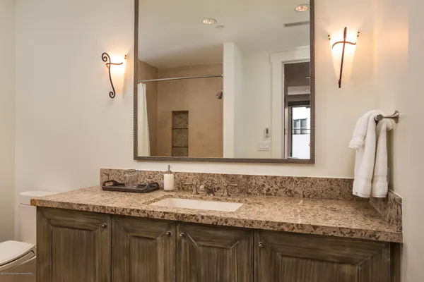 a bathroom with a granite countertop sink and a mirror