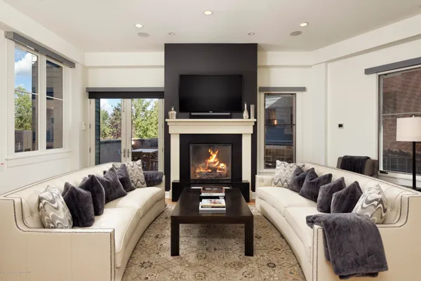 a living room with furniture a flat screen tv and a fireplace