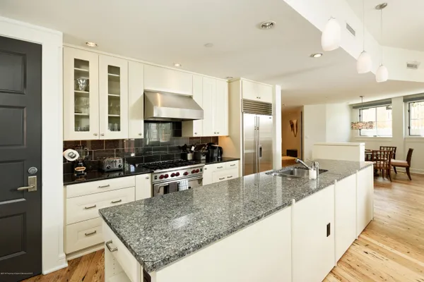 a kitchen with stainless steel appliances granite countertop a sink stove and refrigerator