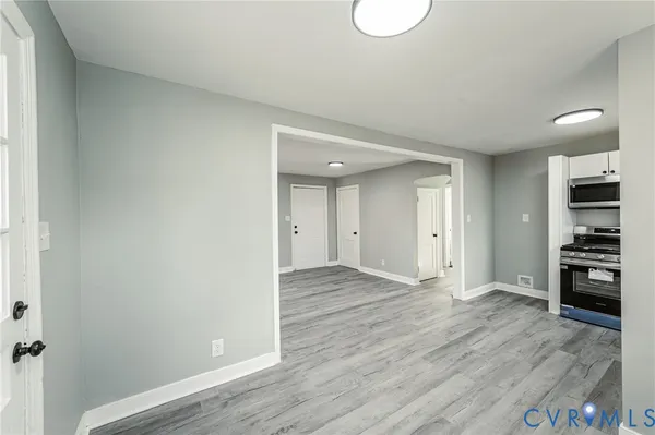a view of empty room with wooden floor and window