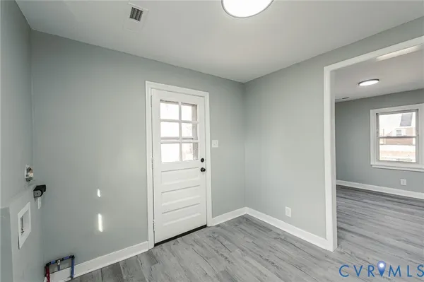 an empty room with wooden floor and windows