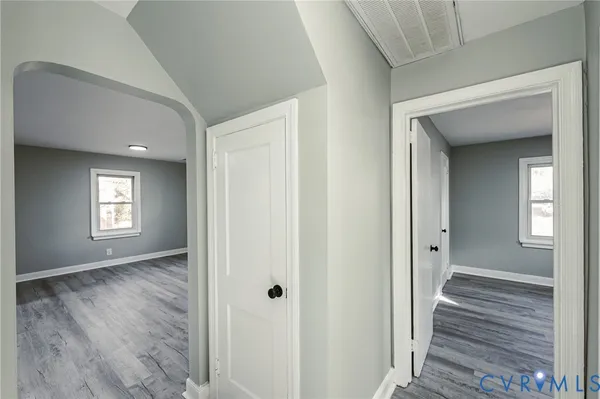 a view of a hallway with wooden floor and a living room