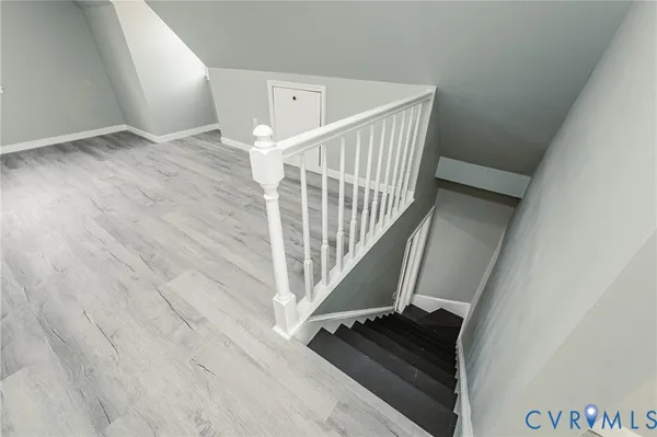 a view of staircase with wooden floor and white walls