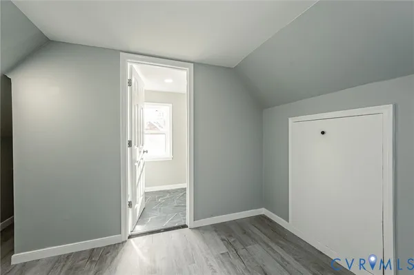 an empty room with wooden floor and door