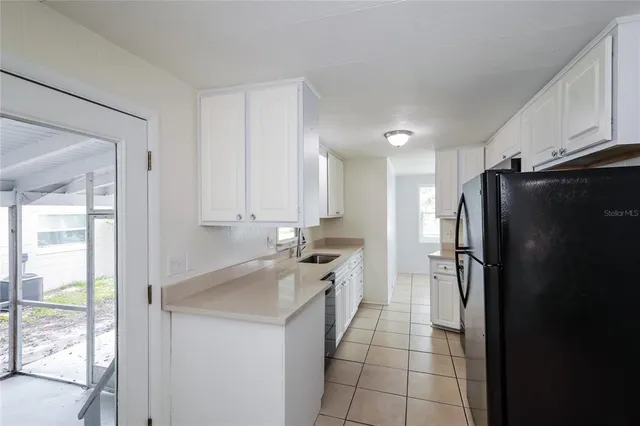 a kitchen with a refrigerator a sink and cabinets