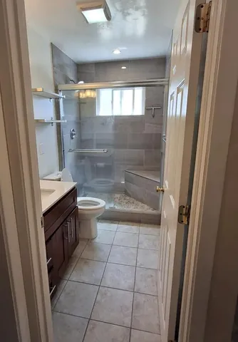 a bathroom with a granite countertop sink toilet and shower