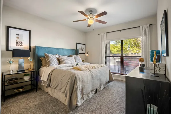 a bedroom with a bed and a large window
