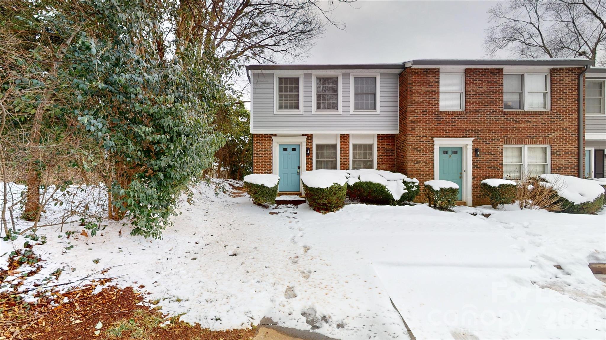 a view of a house with a yard covered in snow