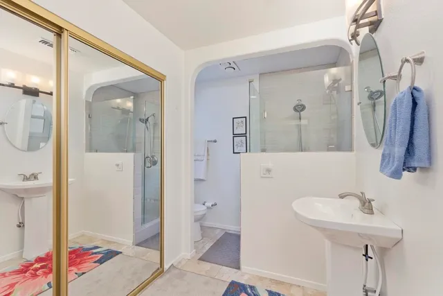 a bathroom with a sink a toilet and shower