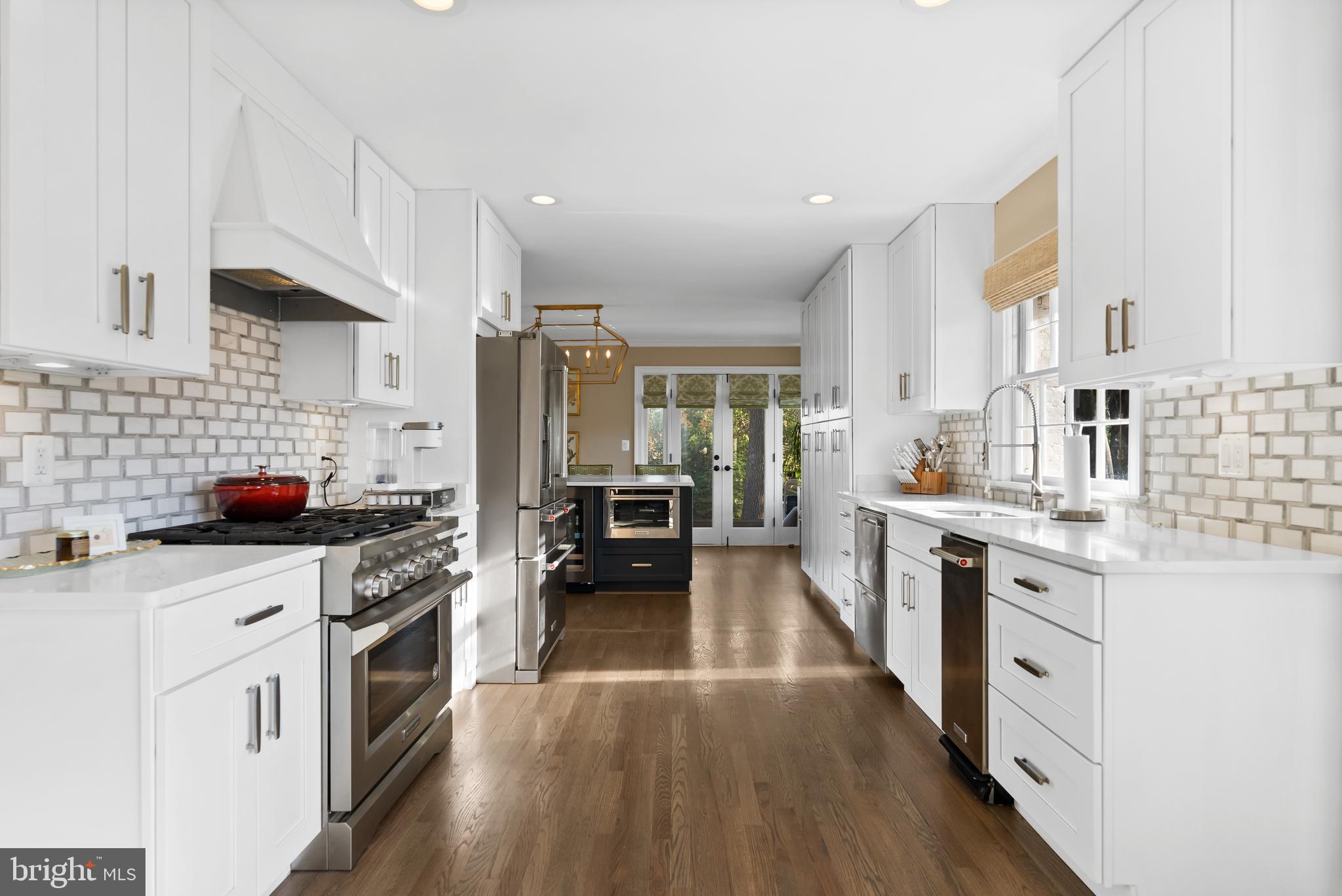 1101 Gatewood Drive Alexandria, VA 22307 - Photo 22 of 63 a kitchen with stainless steel appliances a stove top oven a sink a refrigerator white cabinets and wooden floor