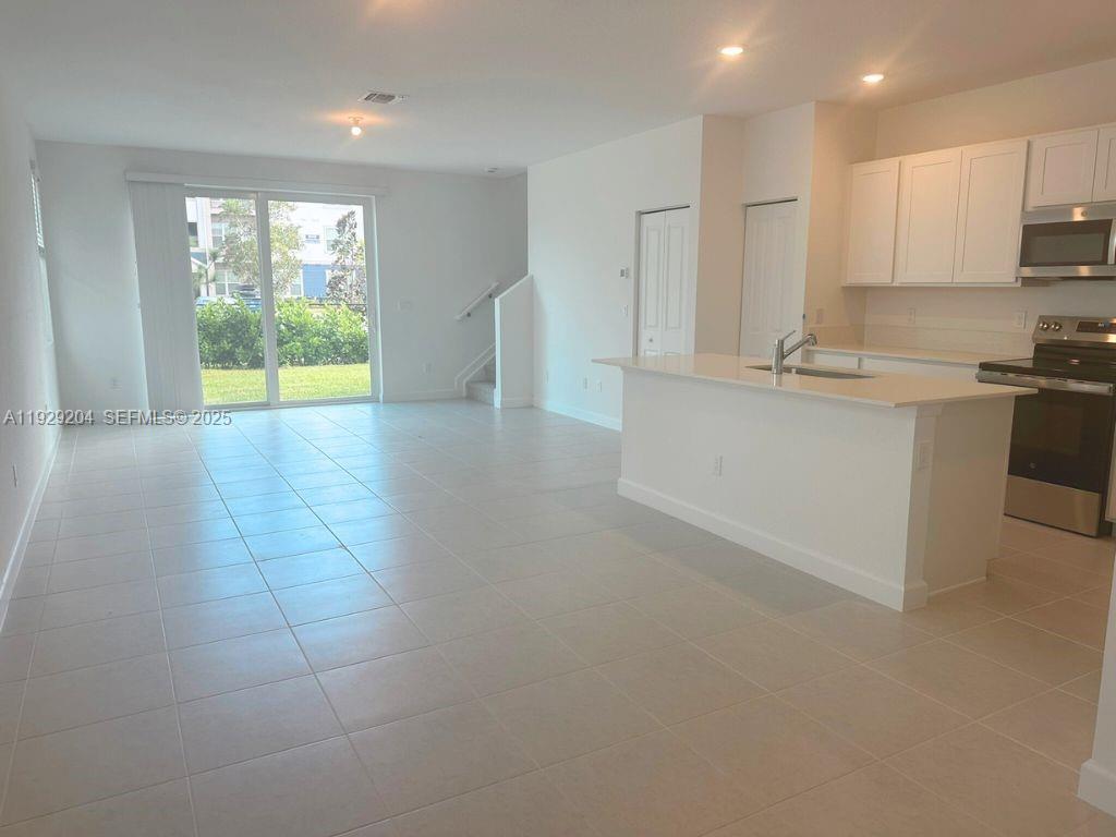 393 Southeast Crossoak Lane Port St. Lucie, FL 34984 - Photo 2 of 10 a kitchen with stainless steel appliances granite countertop a stove a sink and a refrigerator
