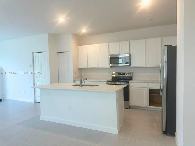 a kitchen with stainless steel appliances granite countertop a stove a sink and a refrigerator