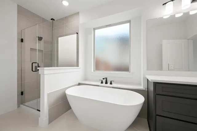 a spacious bathroom with a tub sink and mirror