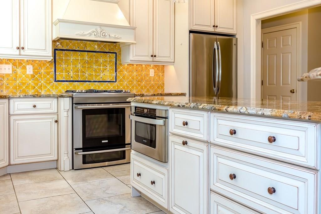 38 Bowditch Road Sudbury, MA 01776 - Photo 13 of 42 a kitchen with granite countertop white cabinets and white appliances