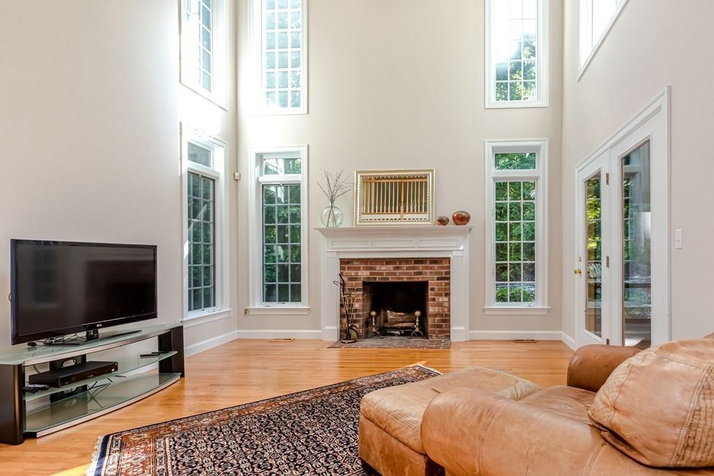 38 Bowditch Road Sudbury, MA 01776 - Photo 9 of 42 a living room with furniture a flat screen tv and a fireplace
