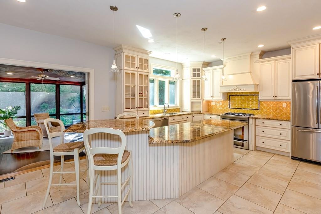 38 Bowditch Road Sudbury, MA 01776 - Photo 10 of 42 a large kitchen with cabinets chairs and stainless steel appliances