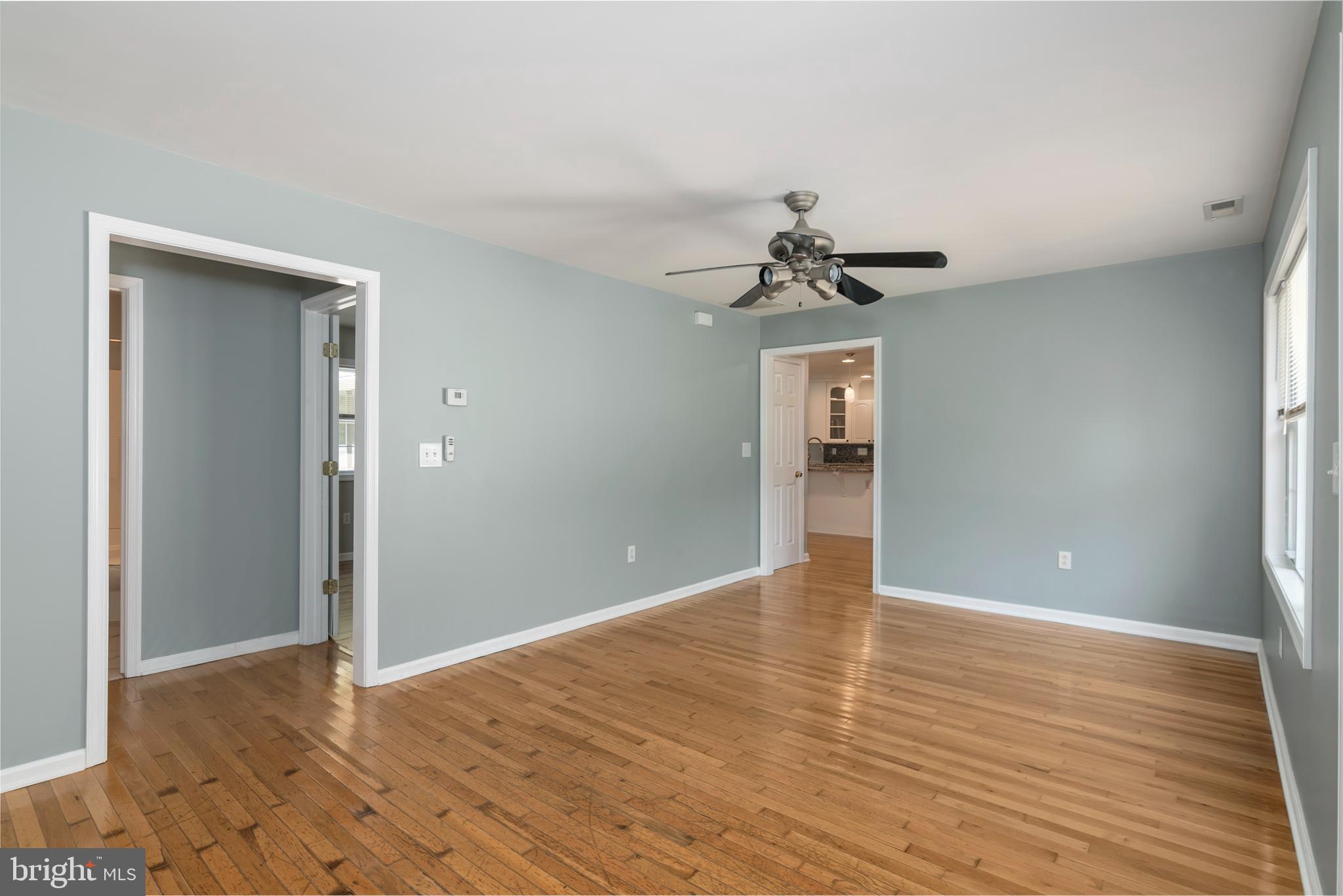 6824 Hopkins Neck Road Easton, MD 21601 - Photo 19 of 45 a view of an empty room with wooden floor and a ceiling fan
