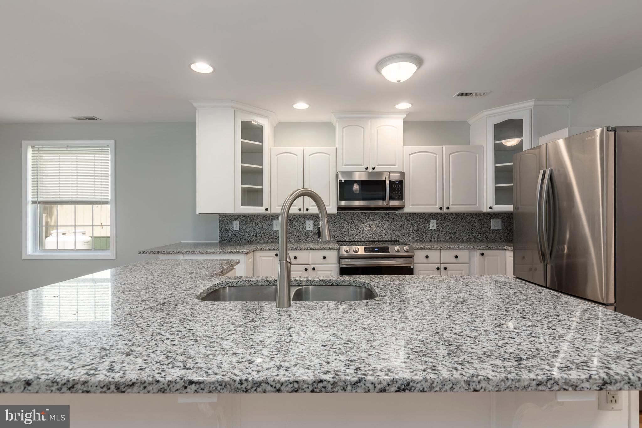 6824 Hopkins Neck Road Easton, MD 21601 - Photo 6 of 45 a kitchen with stainless steel appliances granite countertop a sink stove and refrigerator