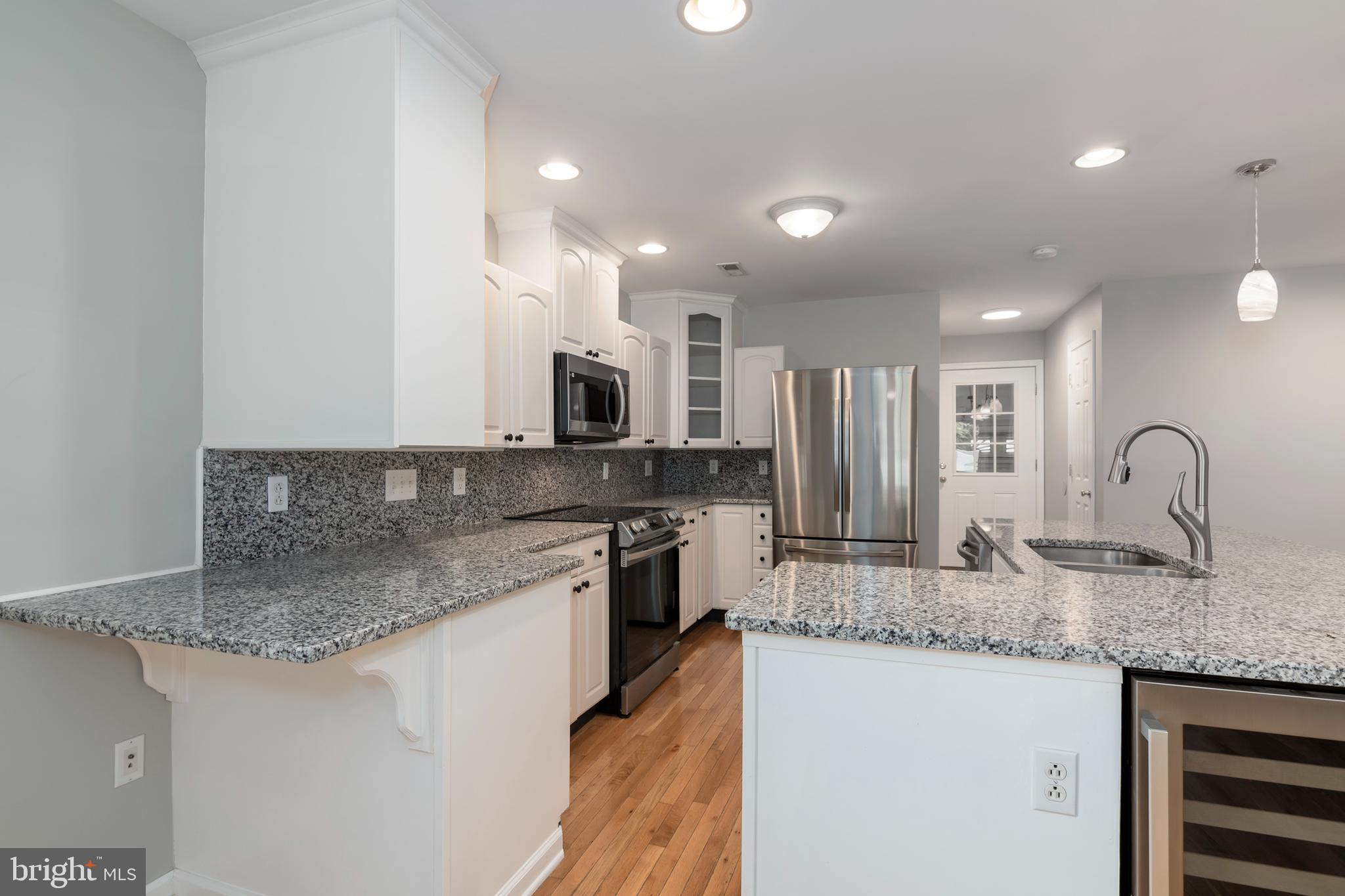 6824 Hopkins Neck Road Easton, MD 21601 - Photo 8 of 45 a kitchen with stainless steel appliances granite countertop a sink stove and cabinets