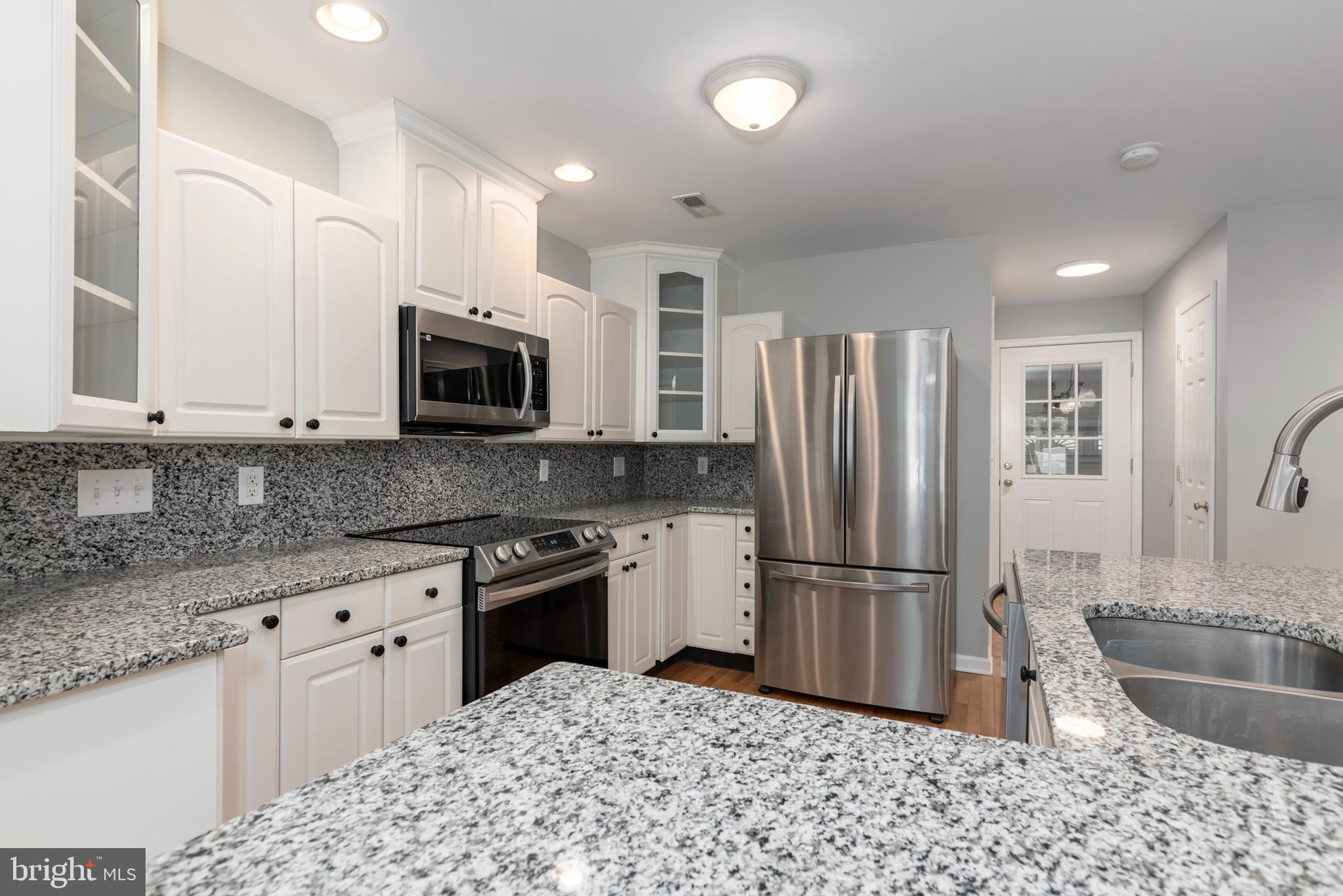 6824 Hopkins Neck Road Easton, MD 21601 - Photo 9 of 45 a kitchen with granite countertop a refrigerator and a sink